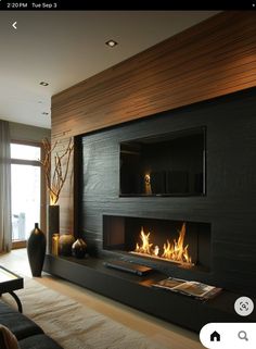 a living room with a fire place in the center and two vases next to it