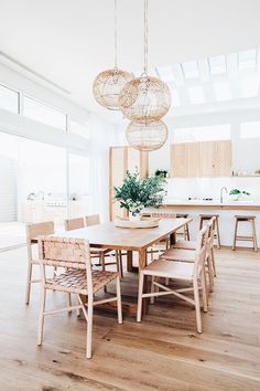 a dining room table with chairs and lights hanging from the ceiling