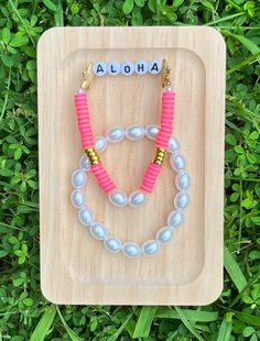 The Preppy Summer Bracelet Duo Set includes an aloha bracelet with the word aloha surrounded by starfish, pearls, and pink, and orange clay beads. The second bracelet consists of pearl beads and can be worn with other bracelets also! Personalized Pink Beaded Bracelets For Beach, Pink Pearl Bracelet With Multicolored Beads For The Beach, Pink Pearl Bracelet With Colorful Beads For Beach, Pearl Bracelet With Letter Beads For The Beach, Personalized Pink Bracelets For Beach, Aloha Bracelet, Diy Christmas Canvas, Clay Bead Bracelet, Summer Bracelet