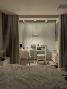 a bedroom with a bed, desk and chair next to a wall that has vertical blinds on it