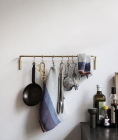 kitchen utensils hanging on the wall above a counter