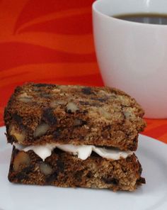 two pieces of food on a plate next to a cup of coffee