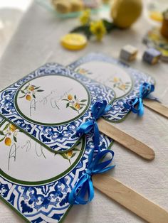 two blue and white plates with wooden spoons next to each other on a table