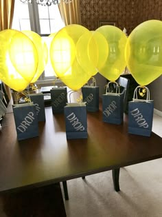 yellow balloons are on the table with bags