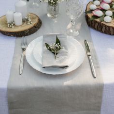 the table is set with white plates and silverware