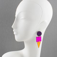 This is part of Chairish’s Costume Jewelry assortment.  Beautiful long Lucite pierced earrings from an artisan designer studio. Flat geometric shape with color-block colors and mirror textured pattern. Assorted tones of neon orange, hot pink, and purple. For pierced ears. No visible maker's mark.  Measurements: 2.82 in long (7.2cm) x 0.88 in wide (2.2 cm).  Please see the measurements noted above in the description for the best approximate dimensions. Modern Purple Earrings For Party, Bold Geometric Earrings With Bold Design, Bold Geometric Designed Earrings, Pink Geometric Earrings, Bold Geometric Earrings, Modern Pink Dangle Earrings, Mirror Texture, Studio Flat, Designer Studio