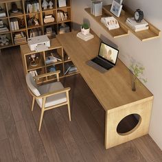 a computer desk with a laptop on top of it in front of a bookshelf