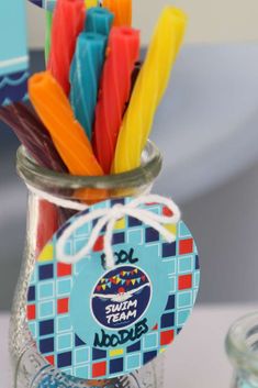 a glass jar filled with colorful candles on top of a table