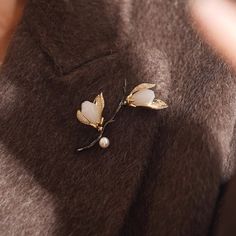 Why We Made This Crafted with meticulous attention to detail, this stunning piece captures the delicate beauty of magnolia blossoms in full bloom. Symbolizing beauty, grace, and resilience, the magnolia flower serves as a timeless emblem of strength and femininity. Wear this brooch as a reminder of your own inner beauty and the power of resilience. Product Details MADE FROM Brass, Zircon, Freshwater Pearl, Serpentine MEASUREMENTS Brooch size : 45 x 60mm / 1.8'' x 2.4'' TURN AROUND 2-3 days CARE Elegant Spring Brooch Jewelry, Elegant Spring Gift Brooches, Elegant Spring Brooch, Elegant Flower Brooch For Spring, Magnolia Blossom, Magnolia Flower, Inner Beauty, Flower Brooch, Magnolia