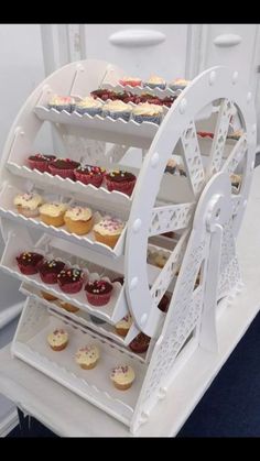 the cupcakes are being displayed on the white carton with wheels for display