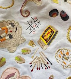 an assortment of embroidered objects on a white cloth