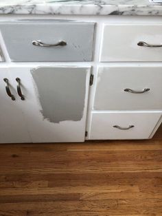 an old white kitchen with wood floors and marble counter tops that have been stripped off