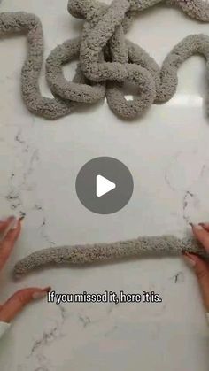 two hands are working on an art project with concrete and cement paper, while another person is