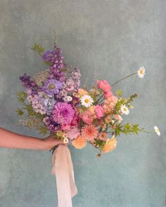 a person holding a bouquet of flowers in their hand