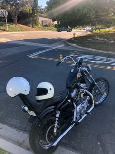 a motorcycle parked on the side of the road with a helmet on it's seat