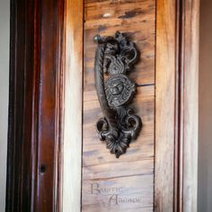 an ornate door handle on the side of a wooden door