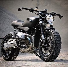 a black motorcycle parked on top of a dirt road