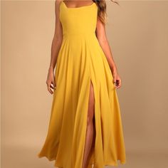 a woman wearing a yellow dress with a thigh high slit