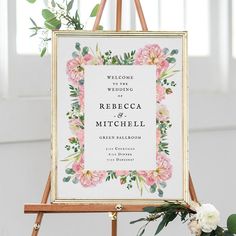 an easer with flowers and greenery on it is holding a welcome sign for the couple