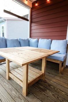 a wooden table sitting on top of a hard wood floor next to a blue couch