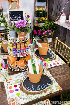 a table topped with lots of potted plants and chalkboards on top of it