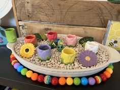 a tray filled with lots of fake flowers and rocks