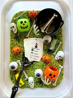 a tray filled with halloween decorations on top of green grass