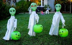 three green halloween decorations in the yard