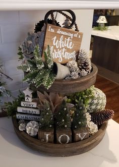 a three tiered tray filled with christmas decorations