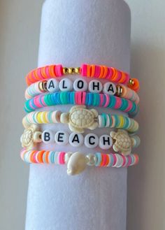 bracelets that say aloha, beach and sea turtle on them with seashells