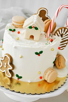 a white cake decorated with gingerbreads, cookies and candy canes on a plate