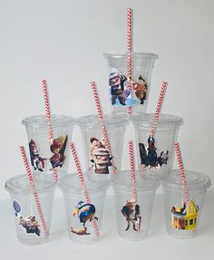 there are many plastic cups with straws on the top and pictures in each cup