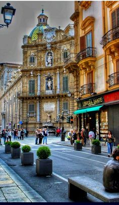 people are walking down the street in front of buildings