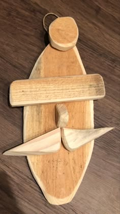 a wooden toy with two knives and a piece of wood in the shape of a boat