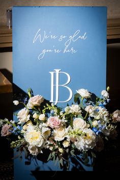 a bouquet of flowers sitting on top of a blue sign