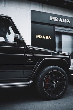 a black jeep parked in front of a prada store