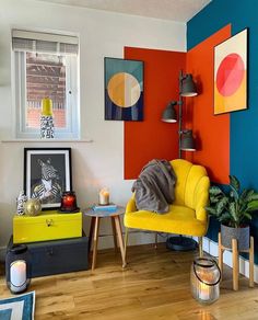 a brightly colored living room with modern furniture and artwork on the wall, including a yellow chair