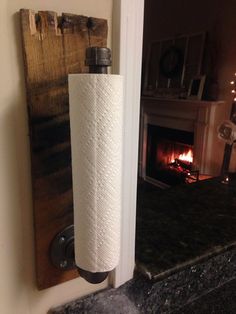 a roll of toilet paper sitting on top of a wall next to a fire place