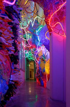 the hallway is lit up with colorful lights and paper streamers hanging from the ceiling