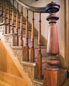 a wooden stair case next to a set of stairs