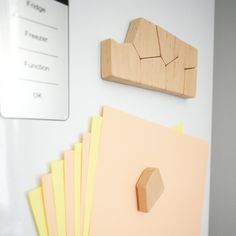 several pieces of wood sitting on top of a white table next to magnets and papers