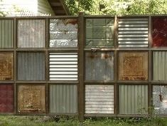 a fence made out of old windows in the grass