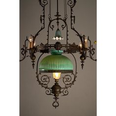 an ornate chandelier with green glass shade hanging from it's centerpiece