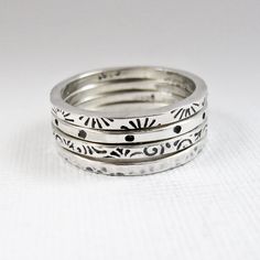 A set of four stacking rings are hand fabricated from sterling silver.  They've been stamped with patterns and have been hammered.  The patterns are oxidized to contrast with the shiny white silver.  The edges are beveled for comfort.  This set includes sunbursts, polka dots, small swirls, and hammered.  Wear them stacked together or one, two, or three at a time.   Because they are made to order, and are handmade, there will be subtle differences from the rings pictured.  Each ring measures about 1.6mm. wide and set together they are just a hair over 7mm. wide. I will also customize the stampings for you, or leave them unpatterned.  There is also the possibility of stamped wording.  Contact me to requst variations.  If you are interested in purchasing rings like these individually, or orde Sterling Silver Rings Boho, Metal Stamped Jewelry, Stacker Rings, Metal Clay Jewelry, Dope Jewelry, Silver Stacking Rings, Jewelry Lookbook, Silver Rings Handmade, Stamped Jewelry