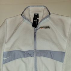 Nike Sportswear Women's Sherpa Jacket White Size Medium Or Small Cover Up In Wool-Like Warmth. The Nike Sportswear Sherpa Jacket Is Made With Plush Fleece For An Ultrasoft, Cozy Feel. A Supersized Swoosh Logo On The Back Brings The Energy To This Color-Blocked Design. Benefits Relaxed Sleeves Provide A Relaxed, Oversized Look. Soft Fleece Has A Cozy, Warm Feel. A Full-Length Zipper Lets You Adjust The Coverage. Product Details Oversized Fit For A Baggy, Spacious Feel 100% Polyester White Fleece Track Jacket, Nike Sporty Fleece Jacket With Pockets, Nike Sporty Fleece Jacket For Sports, Sporty Nike Fleece Jacket, Functional White Fleece Outerwear, Nike Sports Fleece Jacket With Fleece Lining, White Fleece Track Jacket For Sports, Sporty Fleece Jacket For Winter Sports In Fall, Athleisure Fleece Jacket For Winter Sports