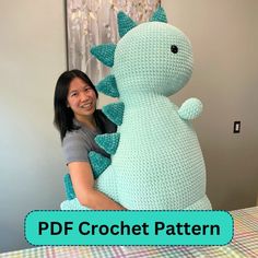 a woman is holding a crocheted dinosaur pillow in front of a bed with the text, free crochet pattern