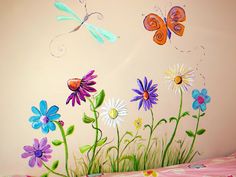 a child's room with flowers and butterflies painted on the wall