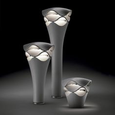 three vases with lights in them on a black background, one is empty and the other two are closed