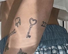 two people with tattoos on their legs and one has a key to the other side