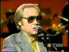 an older man with sunglasses on singing into a microphone